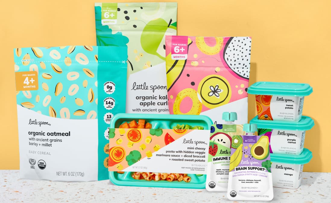 Little Spoon product lineup, including organic oatmeal baby cereal, kale apple curls, banana papaya rings, a Biteables tray, and assorted Babyblends containers, arranged against a yellow background.